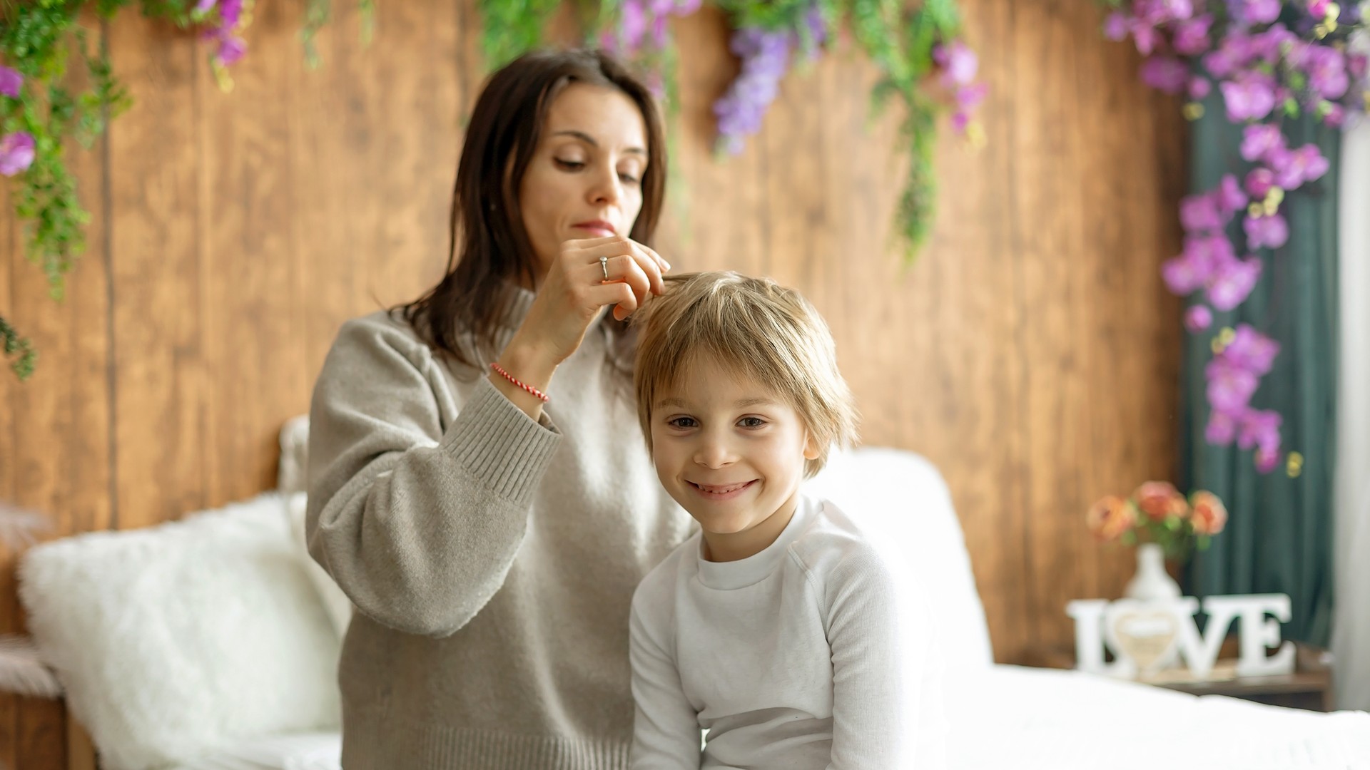 Parent gently checking a child's hair in a calm home setting, representing the stress and reassurance families need during lice treatment.