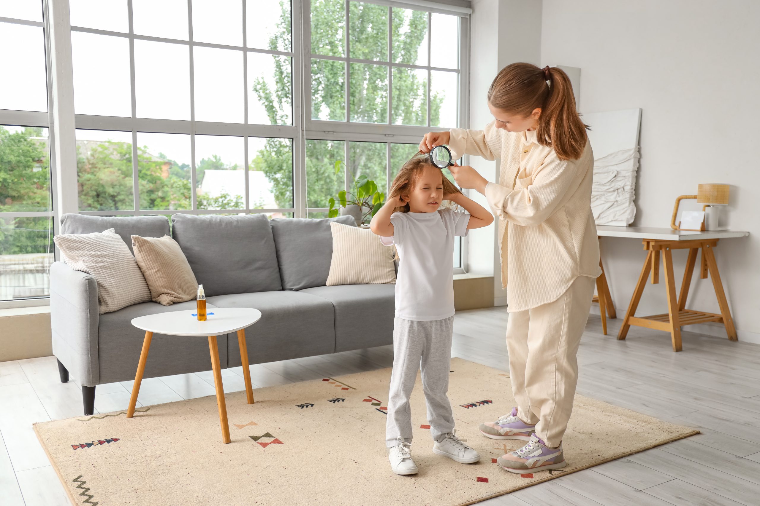 Parent carefully checking a child's scalp at home for head lice and nits.