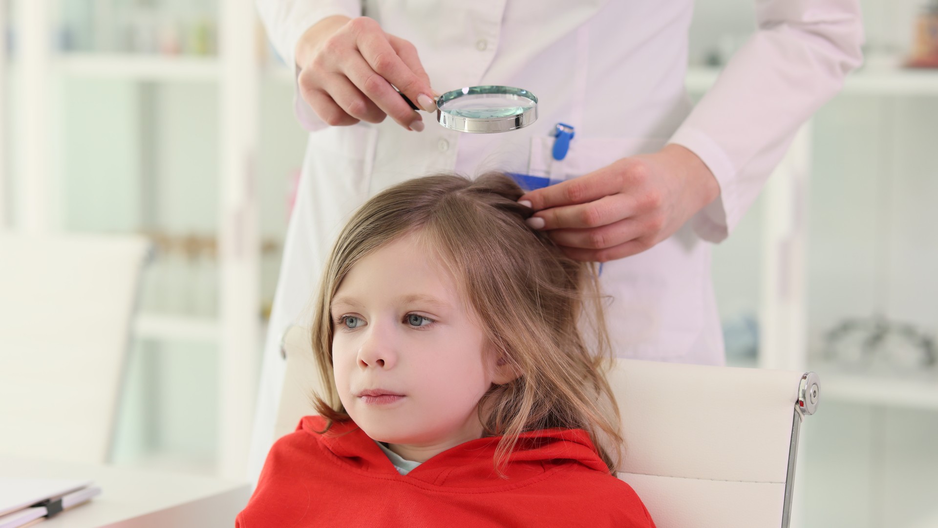 School-age child getting a careful scalp check before returning to class, matching back-to-school lice prevention.