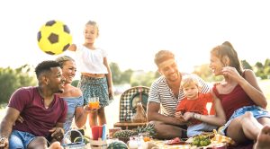 Multiracial Palm Beach County family enjoying a Fourth of July backyard gathering with kids, symbolizing the summer party a lice case shouldn't have to cancel.